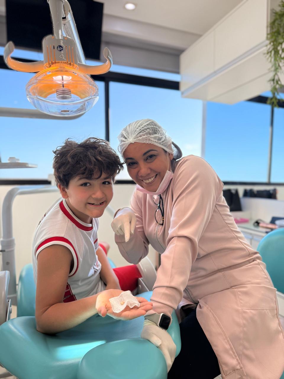 Menino com dente na mão